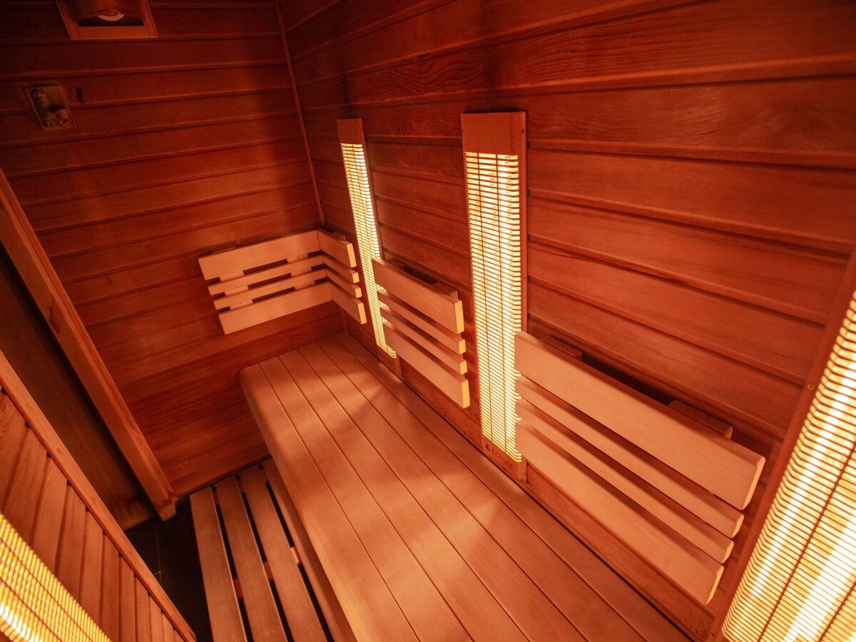 large infrared sauna room with sitting bench and footrest